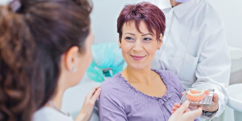 Zahnimplantate: Risiken und Nebenwirkungen lässt sich eine Patientin erklären.